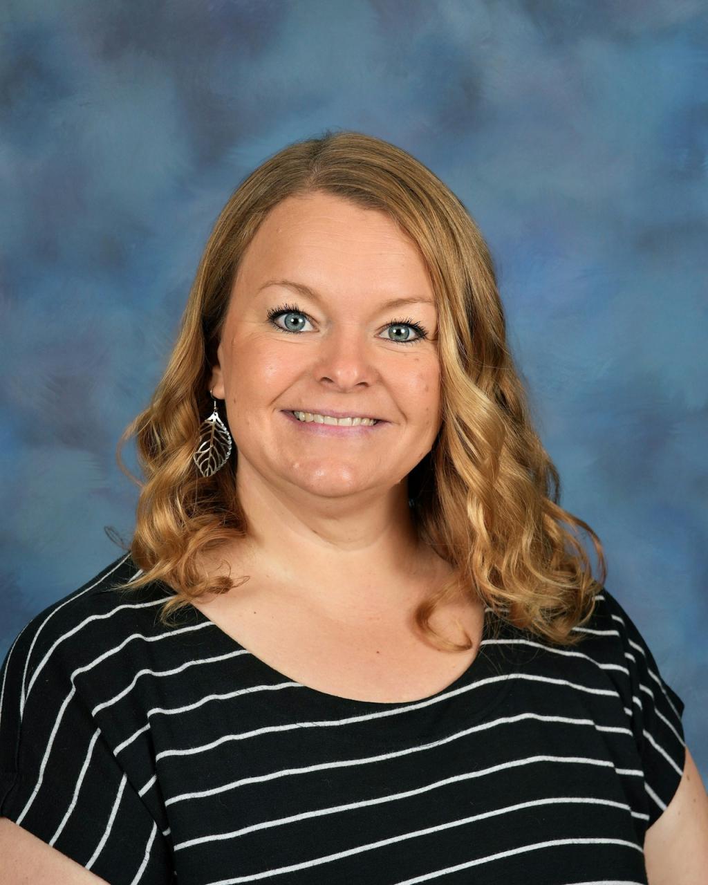 Woman with a black and white striped shirt, silver earrings and a smile